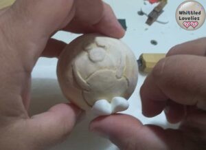 Applying reindeer feet made with cold porcelain to the Christmas ball