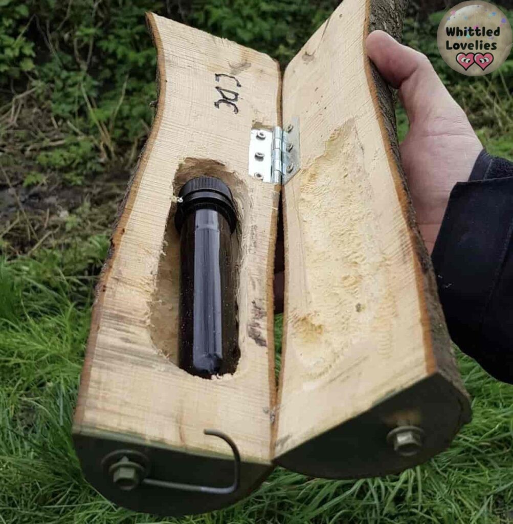 Foto di un pezzo di tronco intagliato in modo da contenere una cache estraibile, come fosse in un bauletto