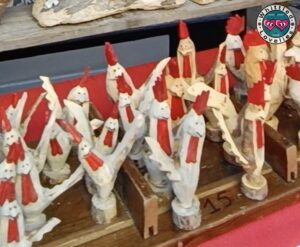 Scultura in legno di un galletto intagliato a mano con dettagli raffinati, simbolo della Fiera di Sant’Orso.